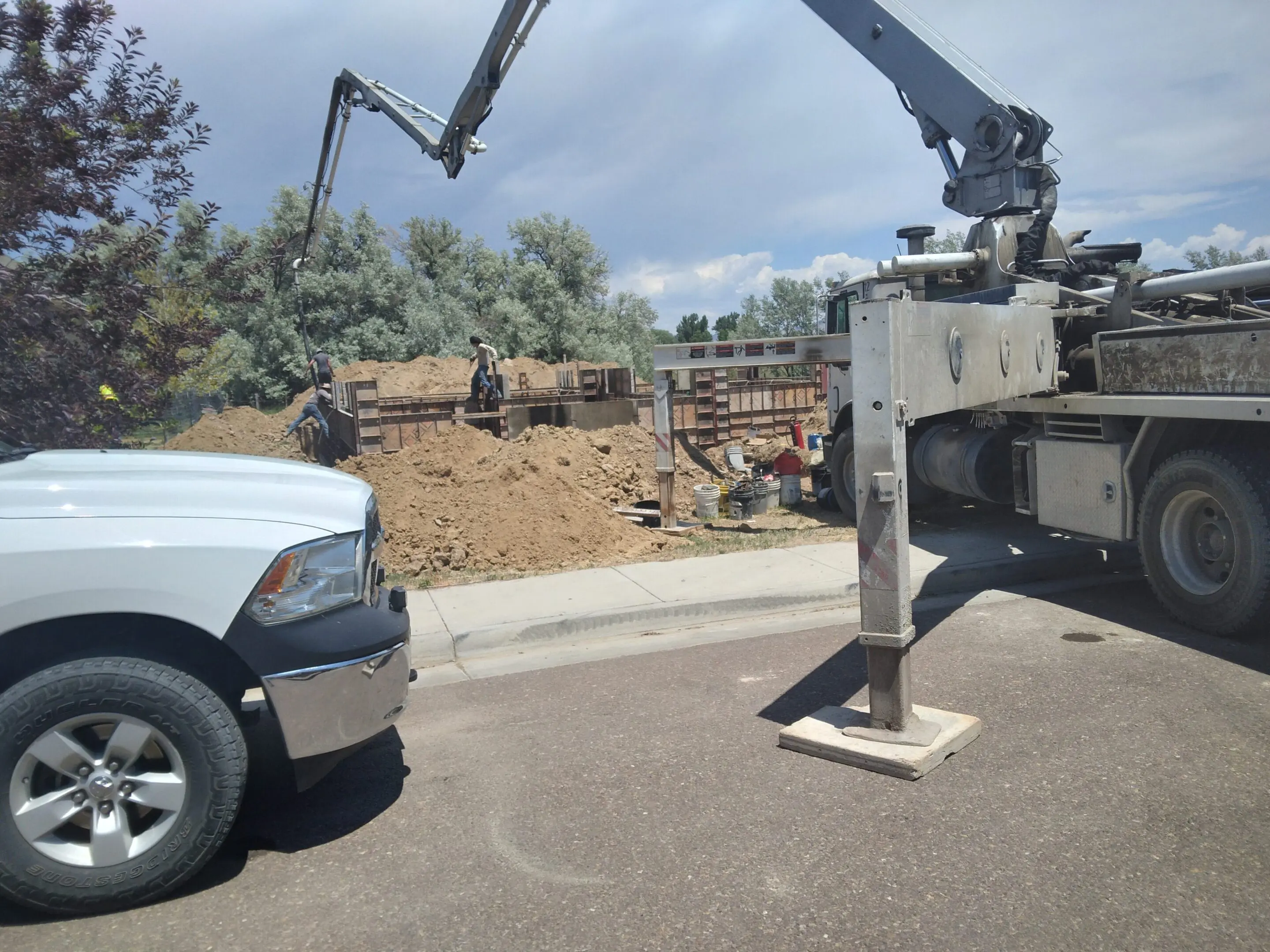 A truck-mounted crane lifting heavy materials at a construction site.