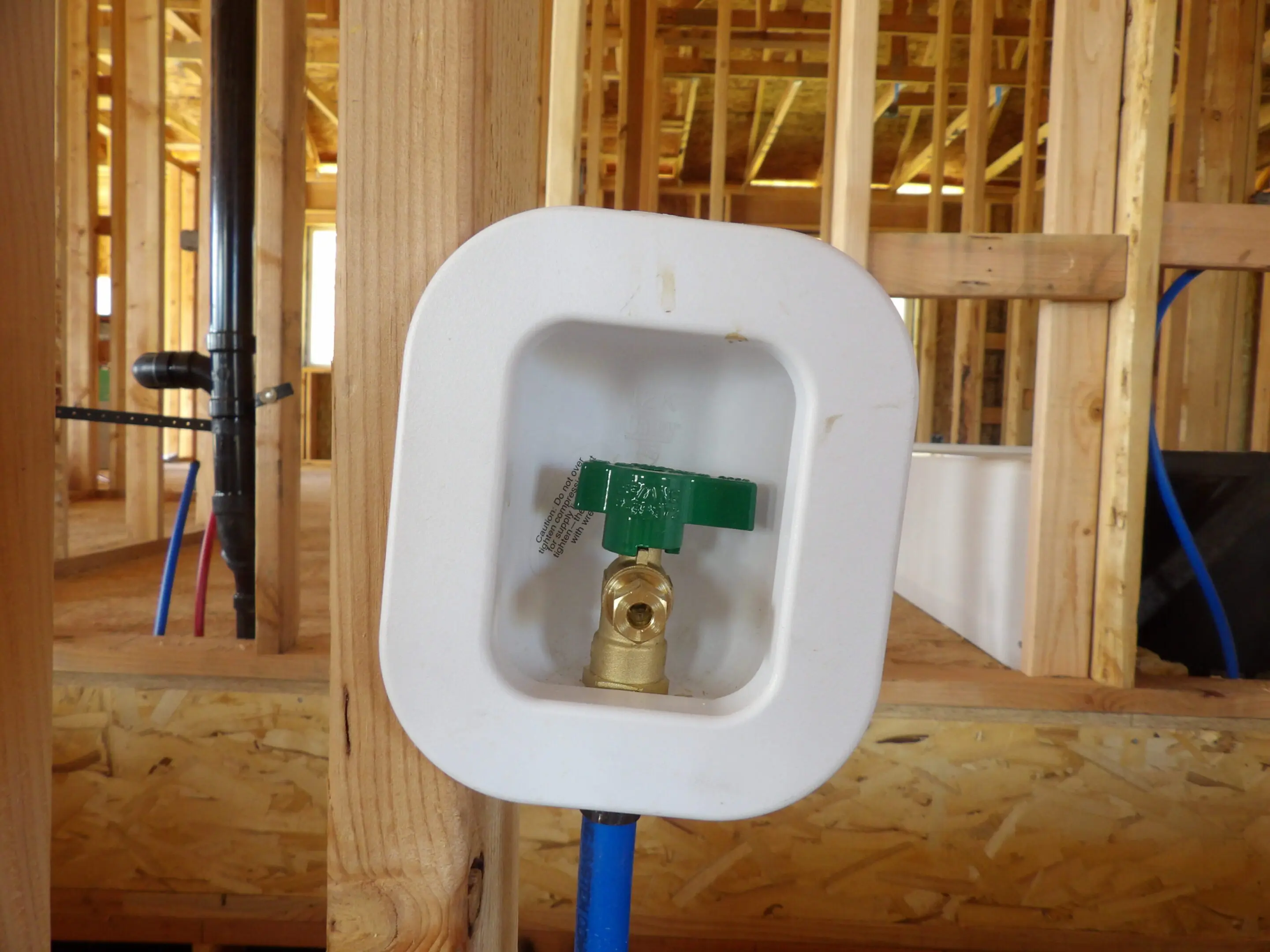 Indoor water supply valve installed in a wooden frame.