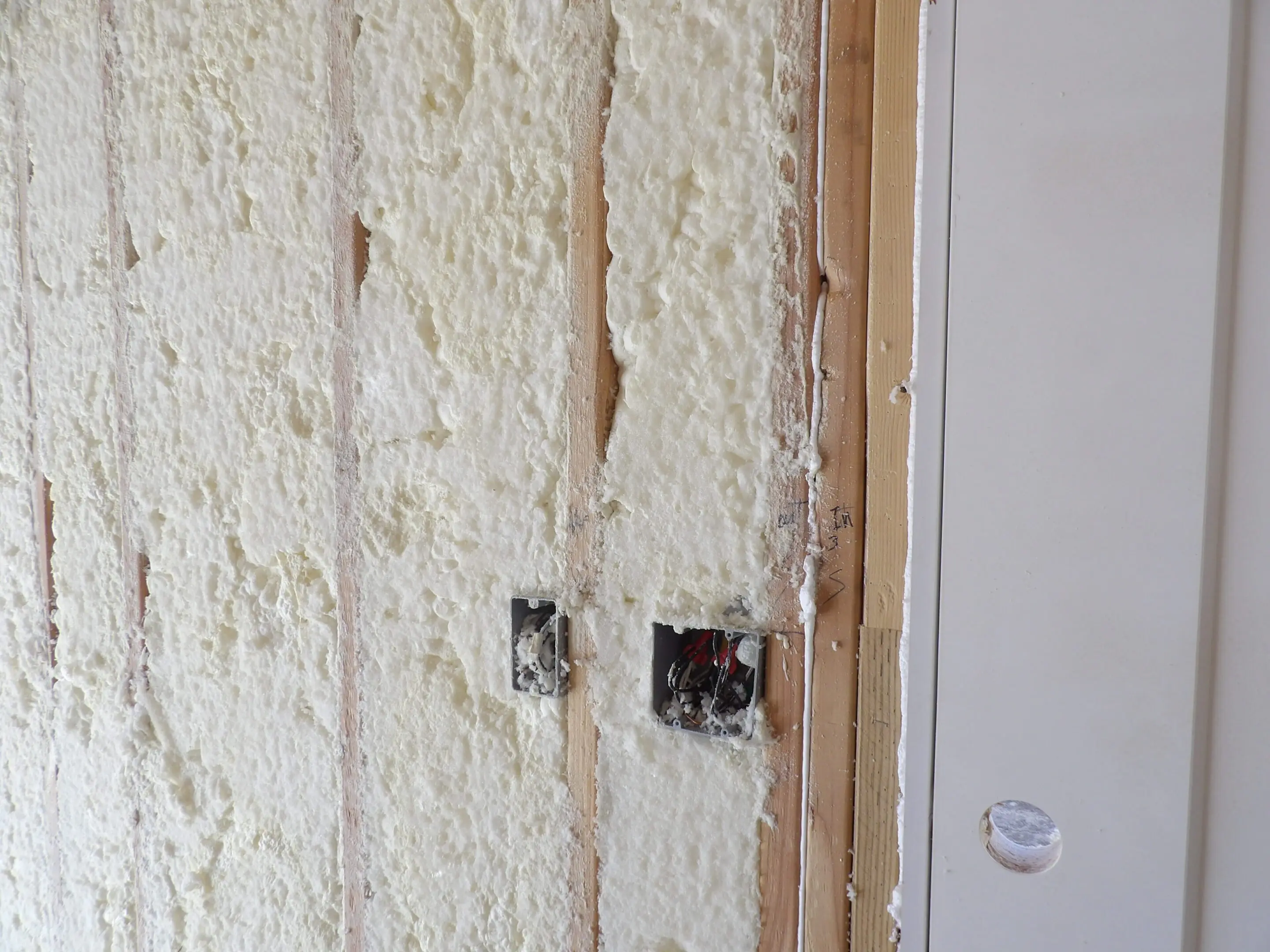 Damaged wall with exposed drywall and electrical outlets.
