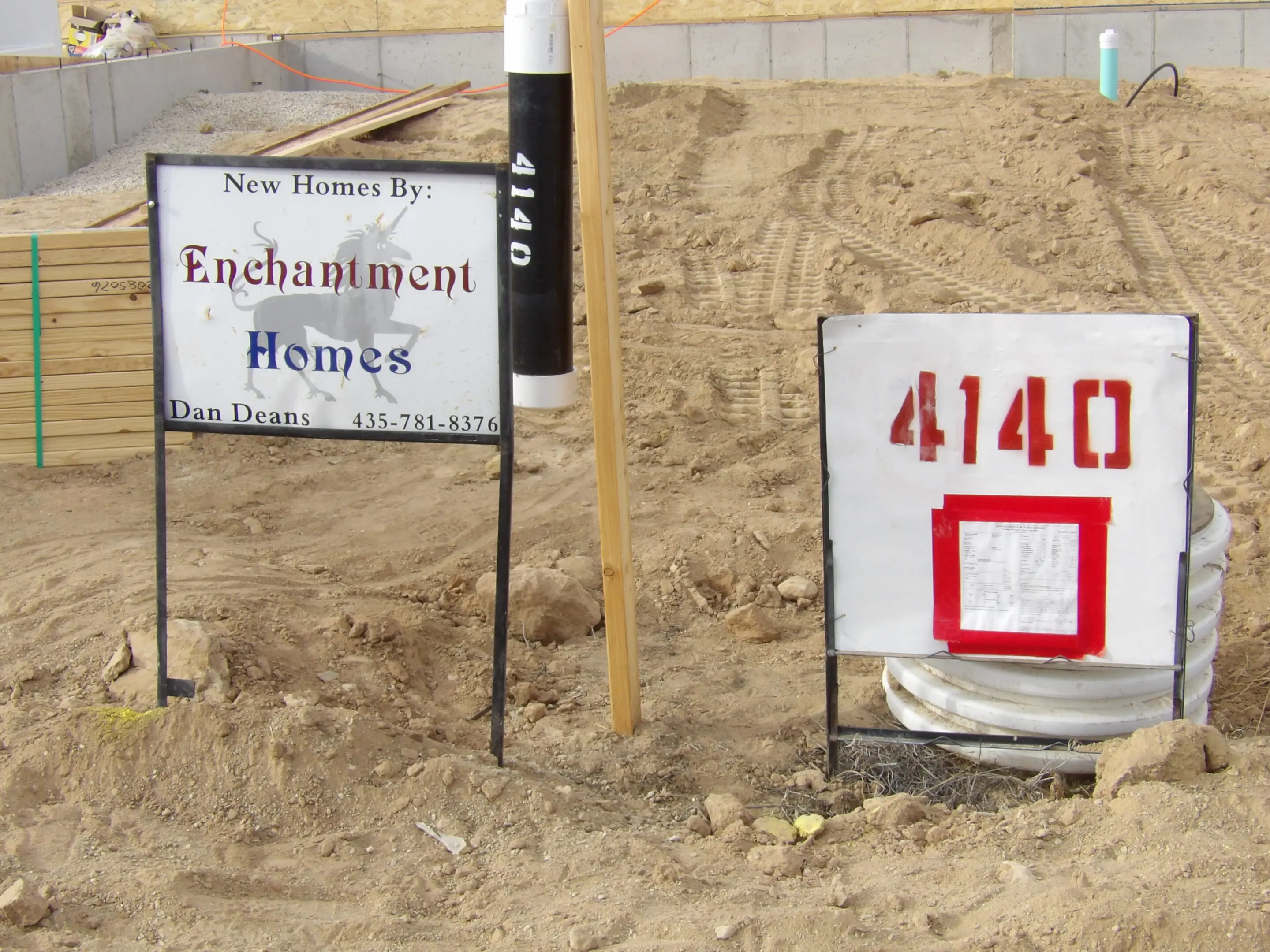 Two street signs partially buried in sand at a beach.