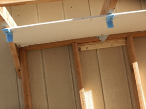 A blue handle is attached to the side of a wall.