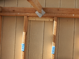 A blue handle is attached to the side of a wall.